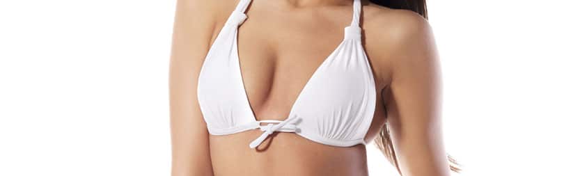 close up of a woman's torso and breasts in white bikini, with solid white background