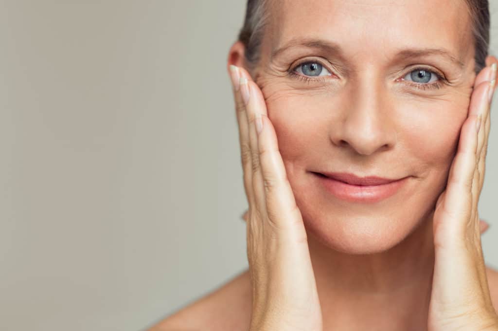 A smiling woman with hands in cheek